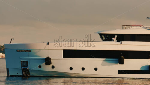 Video - Cannes, France - December 22, 2025: Detailed close up of a luxury yacht hull with a hanging black fender and waterline visible