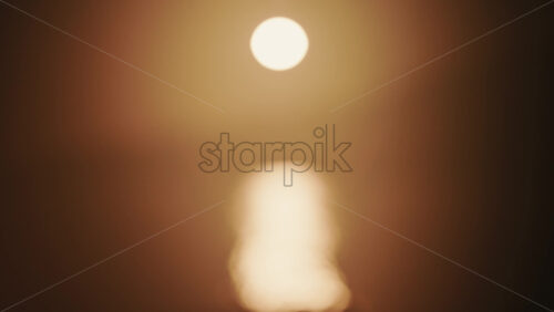 Video - Abstract, out of focus shot of the sun and its reflection on the sea