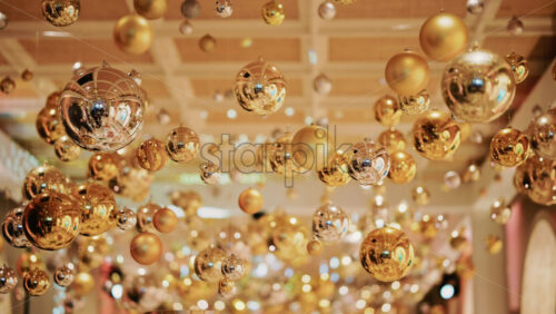 Video - Decorative golden Christmas ornaments suspended in an elegant indoor display