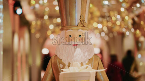 Video - Close up of a Santa Claus figure inside a festive Christmas installation with warm lights and ornaments