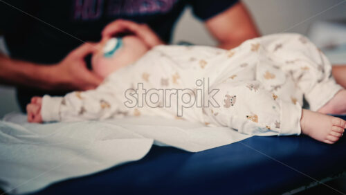 Video - Baby gently cradled by a caregiver during a pediatric session