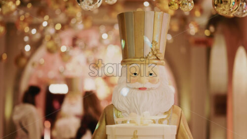 Video - Close up of a Santa Claus figure inside a festive Christmas installation with warm lights and ornaments