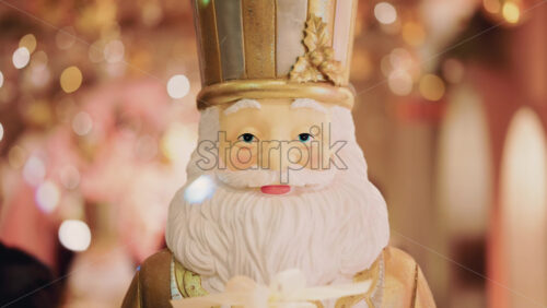 Video - Close up of a Santa Claus figure inside a festive Christmas installation with warm lights and ornaments
