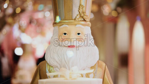 Video - Close up of a Santa Claus figure inside a festive Christmas installation with warm lights and ornaments