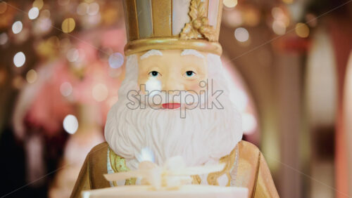 Video - Close up of a Santa Claus figure inside a festive Christmas installation with warm lights and ornaments