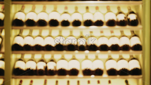 Video - Rows of wine bottles neatly arranged on softly lit shelves in a wine cellar or restaurant interior