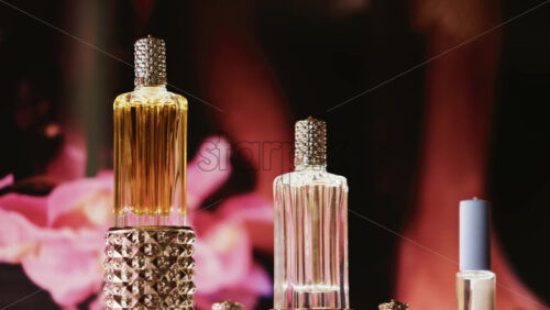 Video - Elegant glass perfume bottles with gold and crystal details, styled with soft lighting and flowers
