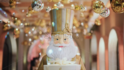 Video - Close up of a Santa Claus figure inside a festive Christmas installation with warm lights and ornaments