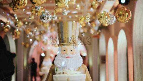 Video - Close up of a Santa Claus figure inside a festive Christmas installation with warm lights and ornaments