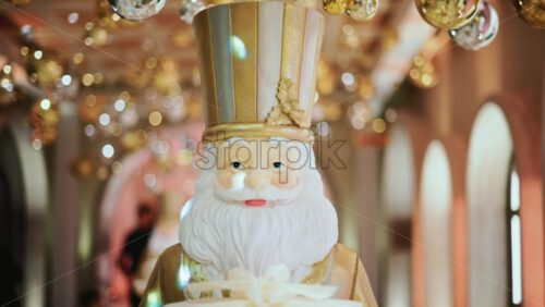 Video - Close up of a Santa Claus figure inside a festive Christmas installation with warm lights and ornaments