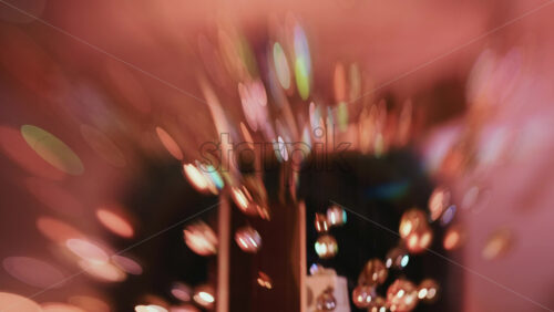 Video - Abstract shot of warm toned Christmas lights and hanging ornaments, blurred creating a festive bokeh effect
