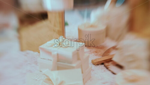 Video - Close up of white, ribbon wrapped gift boxes arranged on a snowy decorative surface, with warm ambient lighting and festive props in the background