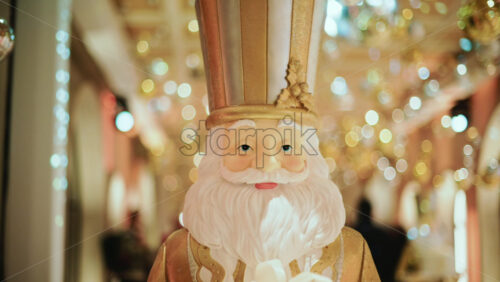 Video - Close up of a Santa Claus figure inside a festive Christmas installation with warm lights and ornaments