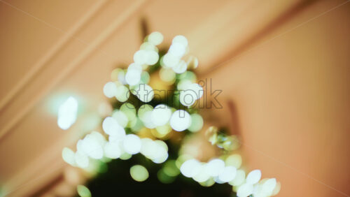 Video - Out of focus Christmas tree decorated with lights and ornaments in a festive indoor setting