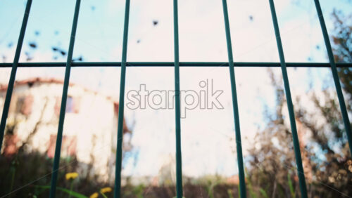 Video - Passenger train passing through, framed by overhead electric cables and surrounding buildings