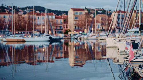 Video - Blurred view of boats lined up along a waterfront with colorful residential buildings behind them