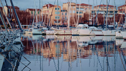 Video - Blurred view of boats lined up along a waterfront with colorful residential buildings behind them