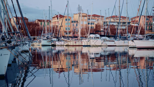 Video - Blurred view of boats lined up along a waterfront with colorful residential buildings behind them
