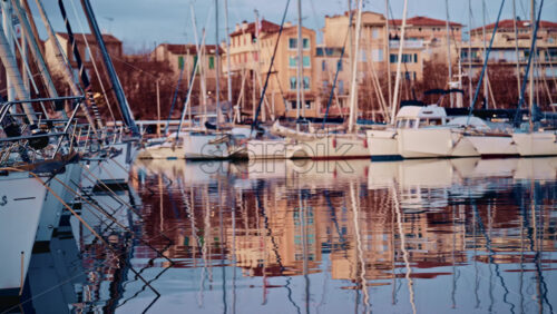 Video - Blurred view of boats lined up along a waterfront with colorful residential buildings behind them