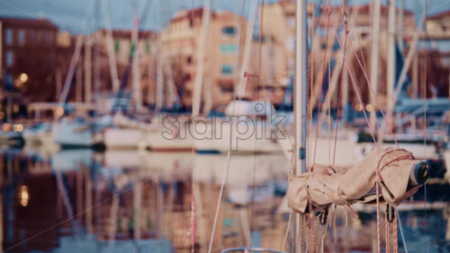 Video - Blurred view of boats lined up along a waterfront with colorful residential buildings behind them