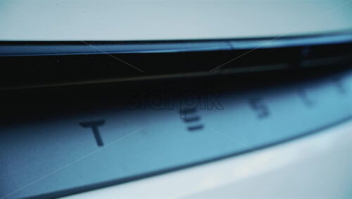 Video - Cannes, France - December 23, 2025: Close up of the Tesla logo on the rear of a white electric vehicle, with clean lines and modern automotive design