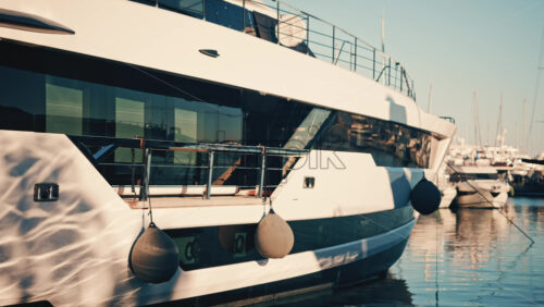 Video - Close up view of a modern luxury yacht hull with fenders hanging at a marina