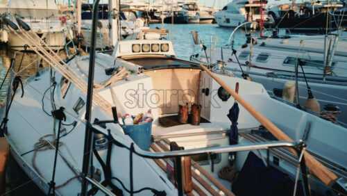 Video - Detailed view of a sailboat cockpit showing ropes, boots, and everyday sailing equipment illuminated by warm afternoon light