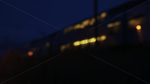 Video - Evening train moving through a fenced railway line in a quiet urban neighborhood