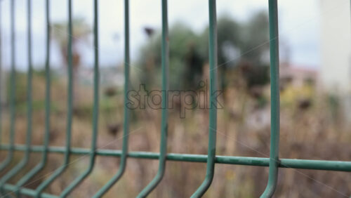 Video - Passenger train passing through, framed by overhead electric cables and surrounding buildings