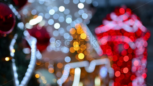 Video - Decorated Christmas tree ornaments in focus with illuminated festive installations blurred in the background