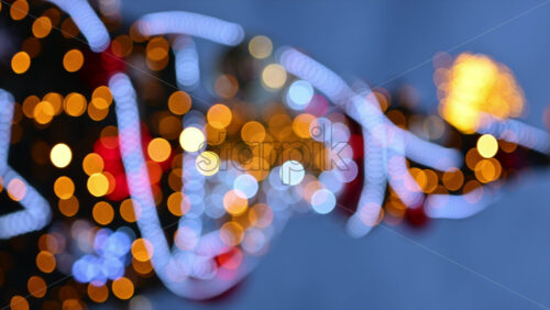 Video - Out of focus Christmas light decorations on a Christmas tree outside. Vertical