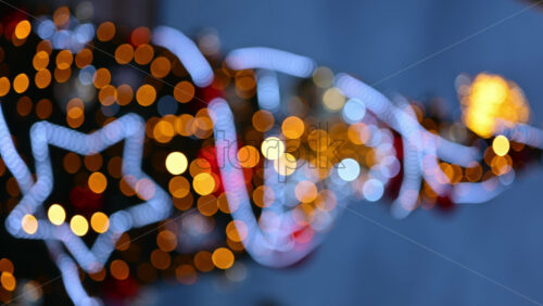 Video - Out of focus Christmas light decorations on a Christmas tree outside. Vertical
