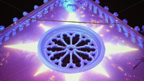 Video - Close up of a window of the Eglise Saint Pierre during nighttime with projection mapping on the church in Bordeaux, France