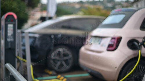 Video - Electric car connected to a public charging station in an outdoor parking area