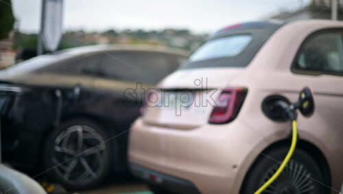 Video - Electric car connected to a public charging station in an outdoor parking area
