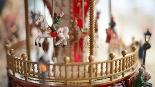 Video - Close up of a miniature vintage carousel with decorative horses and ornate details