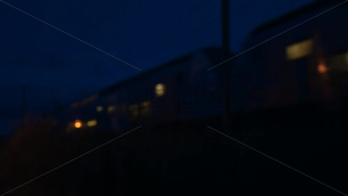 Video - Motion blurred train passing through a station at night, creating a dynamic urban transport scene