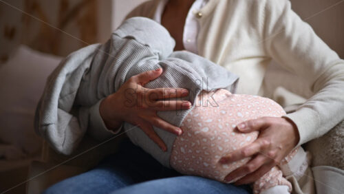 Video - Smiling mom gently holding a baby inside a cafe