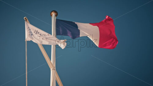 Video - Cannes, France - December 12, 2025: French national flag waving on a mast against a clear blue sky