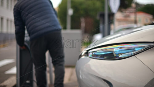 Video - Man unplugging an electric car from a public charging station