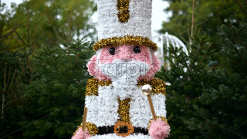 Video - Decorative Christmas nutcracker soldier figure displayed outdoors with trees in the background