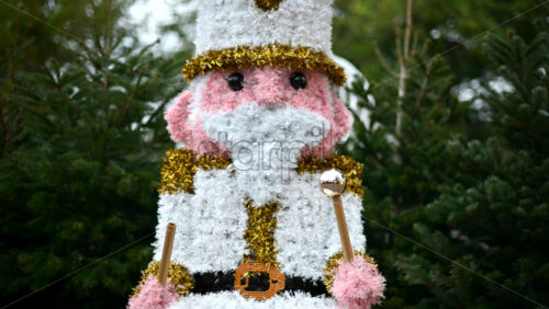 Video - Decorative Christmas nutcracker soldier figure displayed outdoors with trees in the background