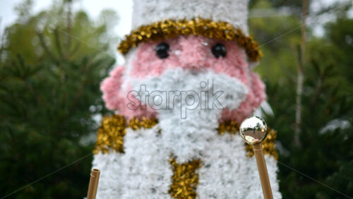 Video - Decorative Christmas nutcracker soldier figure displayed outdoors with trees in the background