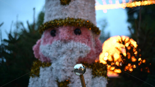 Video - Christmas nutcracker soldier decoration illuminated by festive string lights at dusk