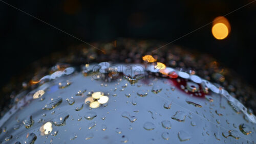 Video - Close up of raindrops on a bauble with colorful lights