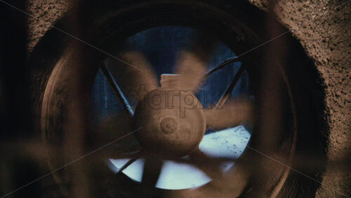 Video - Close up of an industrial ventilation fan spinning inside a concrete structure