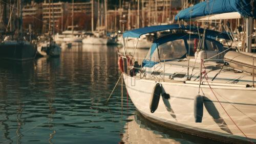 Video - Sailboat docked in a marina with blue canopy and calm water reflections