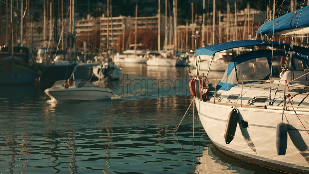 Video - Sailboat docked in a marina with blue canopy and calm water reflections