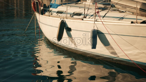 Video - Sailboat docked in a marina with blue canopy and calm water reflections