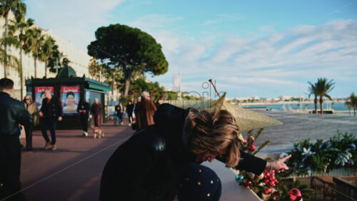 Video - Cannes, France - December 23, 2025: People walking by a golden Christmas star decoration attached to a seafront railing along La Croisette